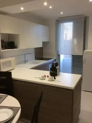 a kitchen with white cabinets and a counter top at Au cœur de la cité médiévale avec petite vue mer in Bonifacio