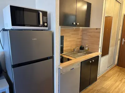 a kitchen with a microwave on top of a refrigerator at Appartement n 216 Moriani plage in Santa-Lucia-di-Moriani