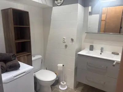 a white bathroom with a toilet and a sink at Appartement n 216 Moriani plage in Santa-Lucia-di-Moriani