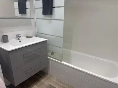 a white bathroom with a sink and a bath tub at Appartement n 216 Moriani plage in Santa-Lucia-di-Moriani