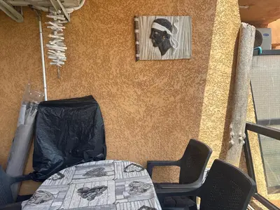 a table and chairs and a picture of a man at Appartement n 216 Moriani plage in Santa-Lucia-di-Moriani