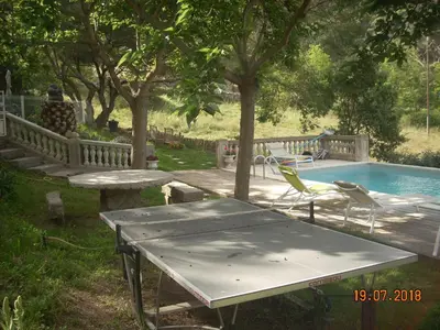a picnic table and chairs next to a swimming pool at Demeure traditionnelle en pierre avec piscine in Sartène