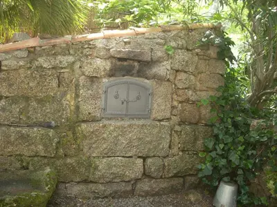 a stone wall with a window on it at Demeure traditionnelle en pierre avec piscine in Sartène