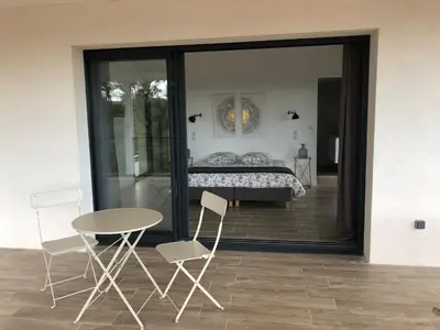 a bedroom with a bed and a table and chairs at VILLA LECCI E MARE in Olmucciu