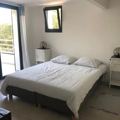 a bedroom with a bed and a mirror on the wall at VILLA LECCI E MARE in Olmucciu