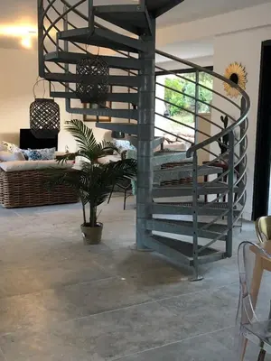 a spiral staircase in a room with a potted plant at VILLA LECCI E MARE in Olmucciu