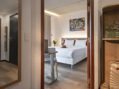 a bedroom with a white bed and a table at ibis Styles Ajaccio Napoleon in Ajaccio