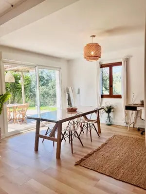 a dining room with a large wooden table and chairs at Loft entre mer et campagne à 5 min d'Ajaccio classé 4 étoiles in Alata