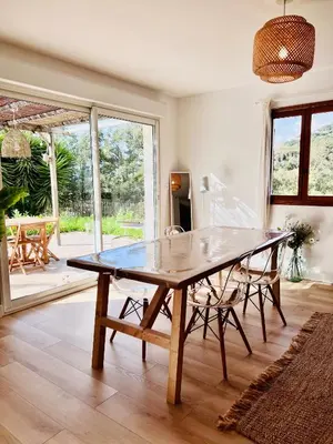 a dining room with a wooden table and chairs at Loft entre mer et campagne à 5 min d'Ajaccio classé 4 étoiles in Alata