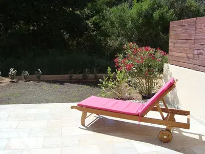 a pink lounge chair with flowers on a patio at PIETROSELLA Plage du RUPIONE in Pietrosella
