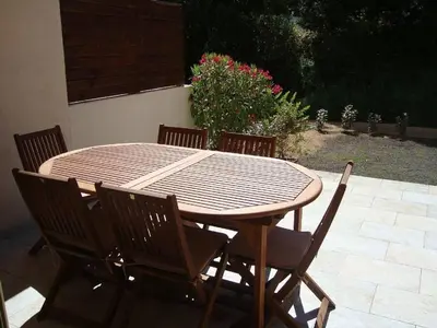 a wooden table with four chairs around it at PIETROSELLA Plage du RUPIONE in Pietrosella