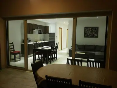 a dining room and living room with a table and chairs at PIETROSELLA Plage du RUPIONE in Pietrosella