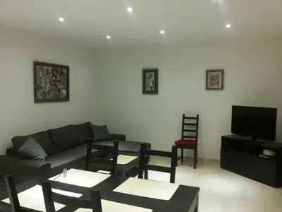 a living room with a couch and chairs and a tv at PIETROSELLA Plage du RUPIONE in Pietrosella