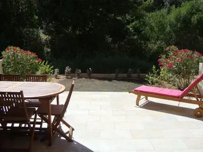 a wooden table and chairs with a table and a bench at PIETROSELLA Plage du RUPIONE in Pietrosella