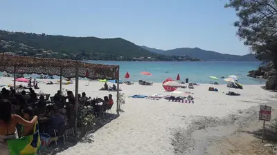 a group of people sitting on a beach at PIETROSELLA Plage du RUPIONE in Pietrosella
