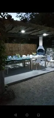 a picnic table with chairs and a fireplace in a yard at Fresi Gustave in Levie