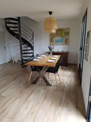 a dining room with a wooden table and a staircase at Entre mer et montagne, en plein maquis in Vallecalle