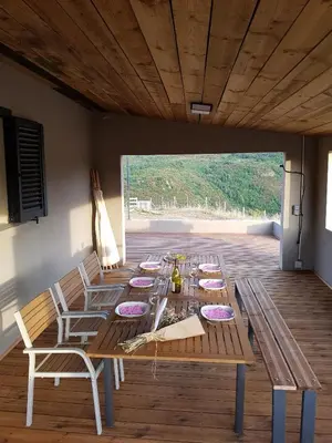 a long wooden table and chairs in a room at Entre mer et montagne, en plein maquis in Vallecalle