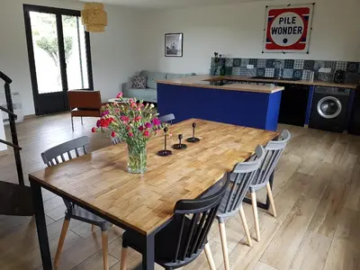 a wooden table with chairs and a vase of flowers on it at En plein maquis,entre mer&montagne in Vallecalle