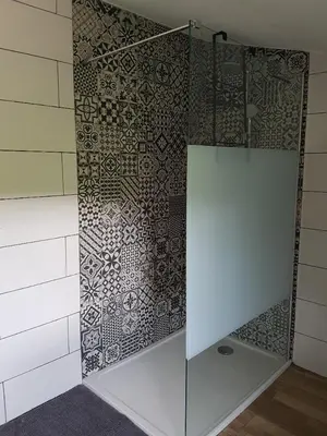 a shower with a glass door in a bathroom at En plein maquis,entre mer&montagne in Vallecalle