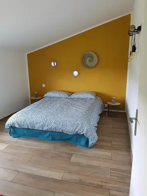 a bedroom with a bed with a yellow wall at En plein maquis,entre mer&montagne in Vallecalle