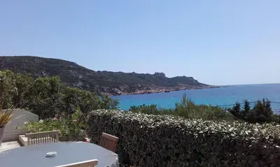 a table and chairs with a view of the ocean at APPARTEMENT PIED DANS L EAU ET VUE MER MAGNIFIQUE in Sartène