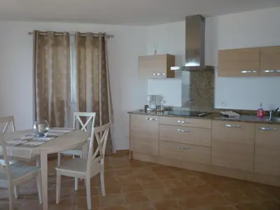 a kitchen with a table and chairs and a dining room at APPARTEMENT PIED DANS L EAU ET VUE MER MAGNIFIQUE in Sartène