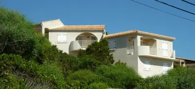 a building on the side of a hill at APPARTEMENT PIED DANS L EAU ET VUE MER MAGNIFIQUE in Sartène