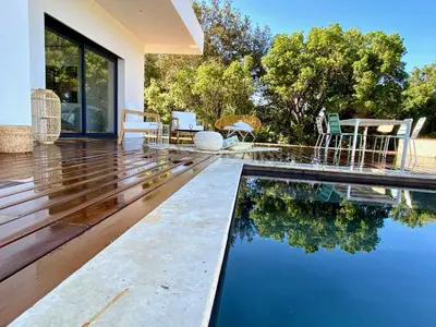 a swimming pool in the middle of a house at Villas de standing avec magnifique vue mer et piscines privées, Sagone in Sagone