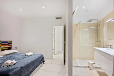 a bedroom with a bed and a shower and a bathroom at Madonuccia - Hypercentral Chic & Cosy in Ajaccio