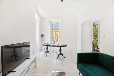 a living room with a couch and a tv and a table at Madonuccia - Hypercentral Chic & Cosy in Ajaccio