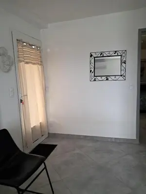 a room with a chair and a television on a wall at Villa Giuseppina in Bonifacio