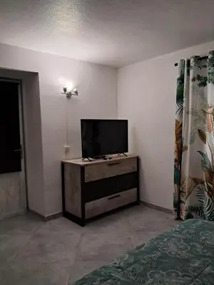 a room with a tv on a dresser with a bed at Villa Giuseppina in Bonifacio