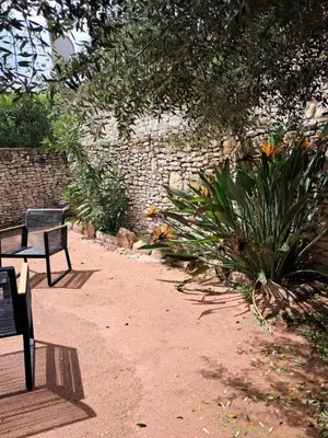 a park bench sitting next to a stone wall at Villa Giuseppina in Bonifacio