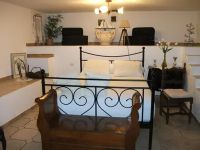 a bedroom with a bed with a chair and a table at T2 dans la région Bastiaise vue sur la mer in Furiani