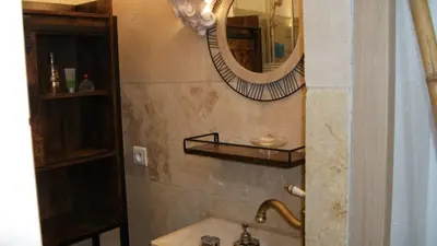 a bathroom with a sink and a mirror at T2 dans la région Bastiaise vue sur la mer in Furiani