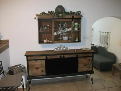 a living room with a wooden dresser and a couch at T2 dans la région Bastiaise vue sur la mer in Furiani