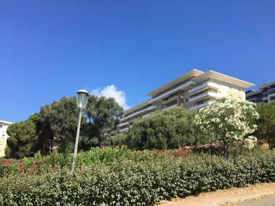 a street light in a park with flowers and a building at Superbe appartement 3 étoiles Ajaccio début Sanguinaires in Ajaccio