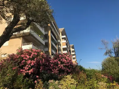 a building with pink flowers in front of it at Superbe appartement 3 étoiles Ajaccio début Sanguinaires in Ajaccio