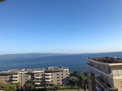 an apartment building with the ocean in the background at Superbe appartement 3 étoiles Ajaccio début Sanguinaires in Ajaccio