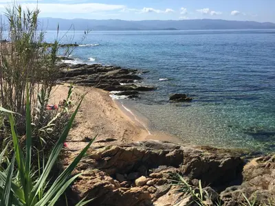 a beach with some rocks and the ocean at Superbe appartement 3 étoiles Ajaccio début Sanguinaires in Ajaccio