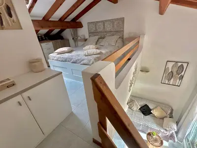 a small bedroom with a bed and a staircase at Marina di pinarello, appt climatisé à 400m de la plage in Zonza