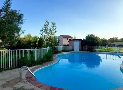 a swimming pool in a yard with a white fence at Marina di pinarello, appt climatisé à 400m de la plage in Zonza