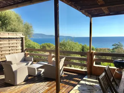 a deck with chairs and a view of the ocean at Residence du valinco Appartement in Olmeto