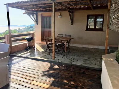 a patio with a table and chairs on a deck at Residence du valinco Appartement in Olmeto