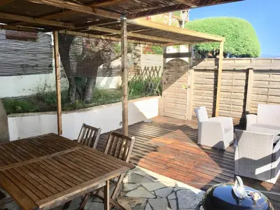 a wooden deck with a wooden table and chairs at Residence du valinco Appartement in Olmeto