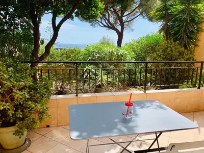 a table on a balcony with a drink on it at Très beau studio à 100m de la plage de Marinella in Ajaccio