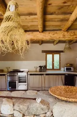 a kitchen with a stove and a table at Résidence de Luxe 4 étoiles à Pietralba, 4 logements piscine chauffée BALAGNE in Pietralba