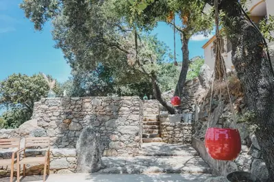 a stone retaining wall with a red bucket at Résidence de Luxe 4 étoiles à Pietralba, 4 logements piscine chauffée BALAGNE in Pietralba