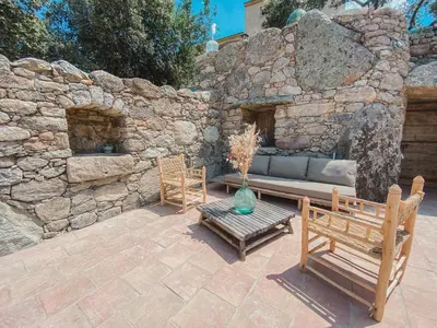 a patio with two benches and a couch in a stone wall at Résidence de Luxe 4 étoiles à Pietralba, 4 logements piscine chauffée BALAGNE in Pietralba